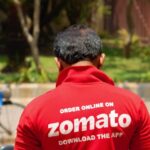 Zomato delivery rider with food order and rising cost graphic