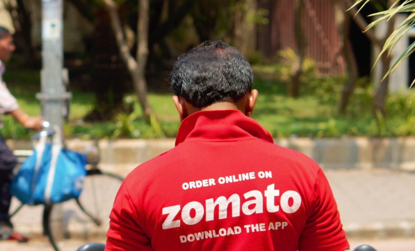Zomato delivery rider with food order and rising cost graphic